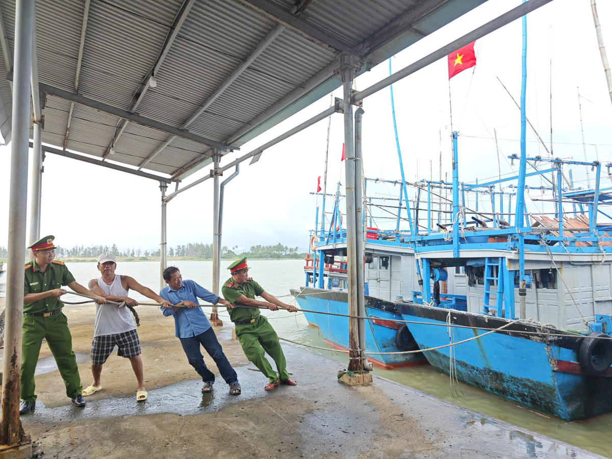 Lực lượng Công an giúp dân di dời tàu thuyền đến nơi neo đậu an toàn. Ảnh: SĐ.