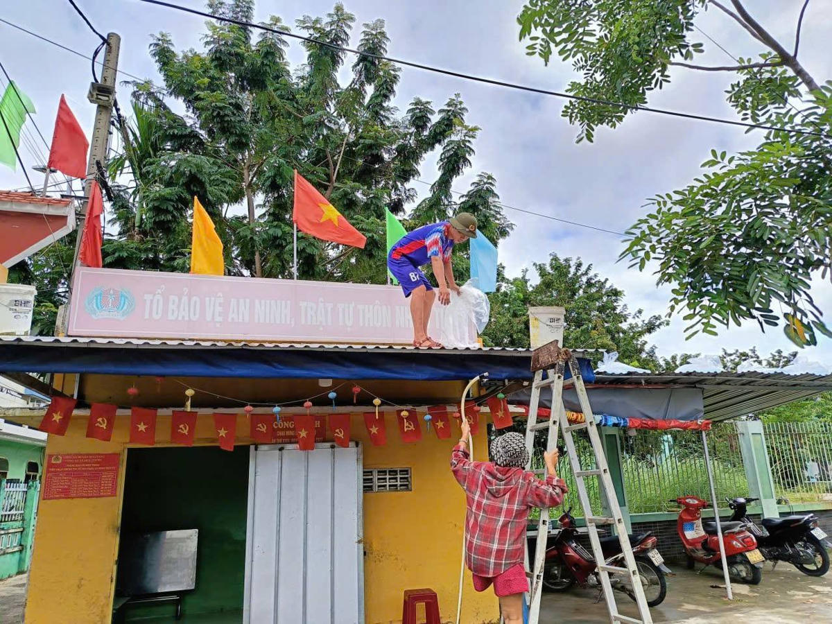 Người dân phường Hòa Xuân gia cố mái nhà. Ảnh: Cẩm Vân.