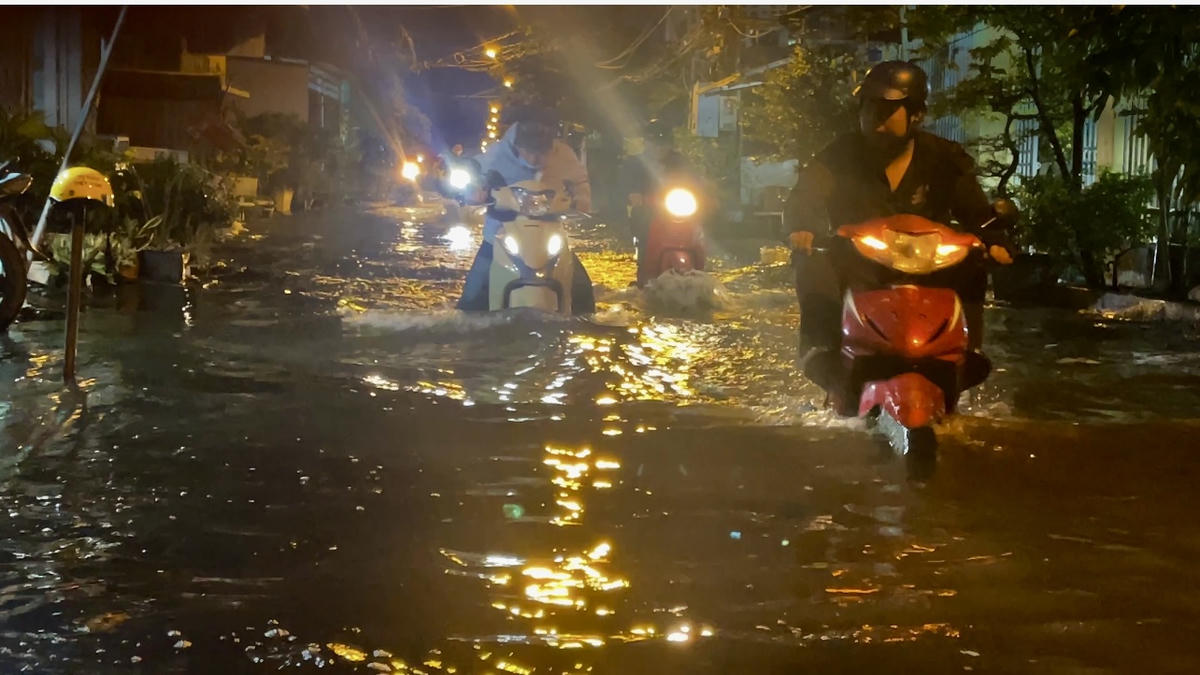 Gần đó, đường Ba Tơ chìm trong nước. Người dân vất vả di chuyển. Ảnh: Đ.Xá.