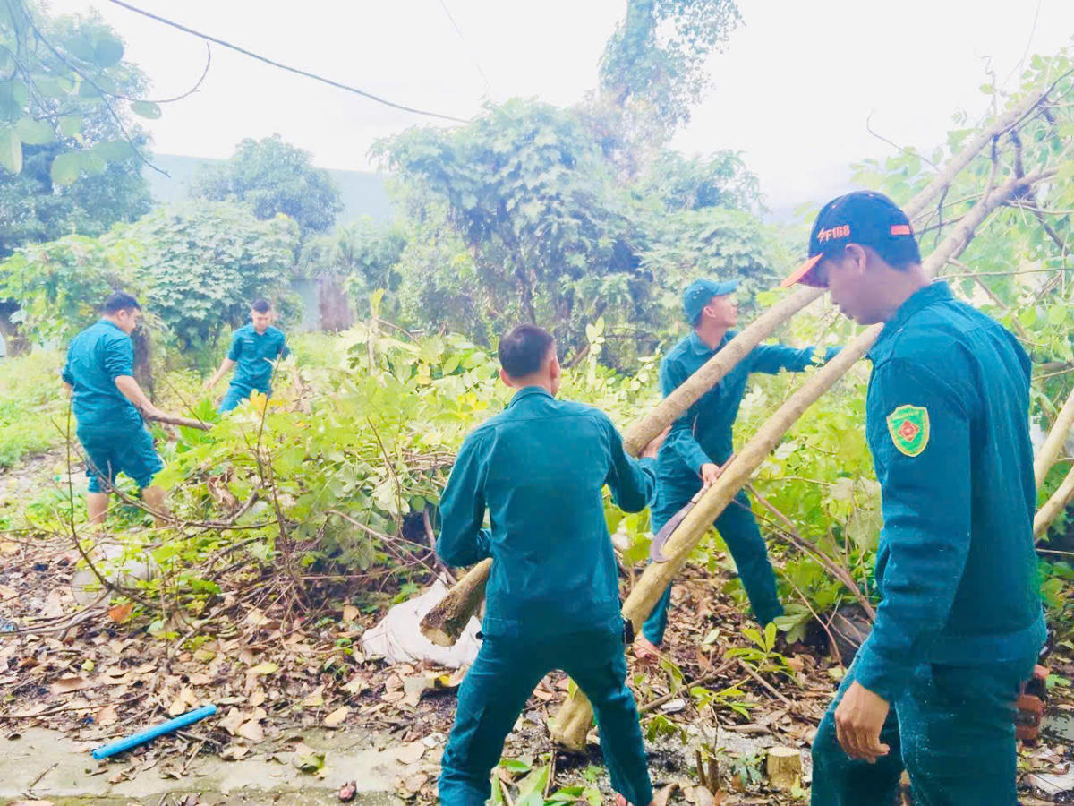 Lực lượng dân quân cắt tỉa cây xanh tại trung tâm. Ảnh: Nguyễn Đức Cường