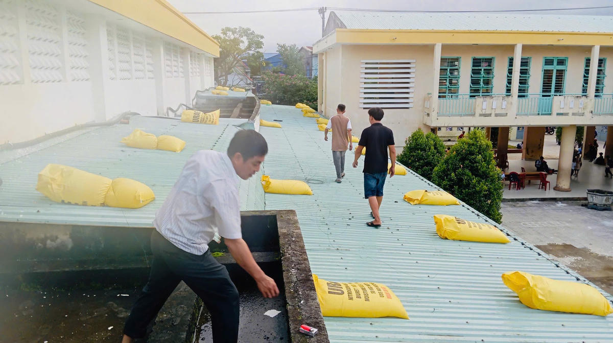 Gia cố mái tôn nhà trường. Ảnh: Nguyễn Tú.