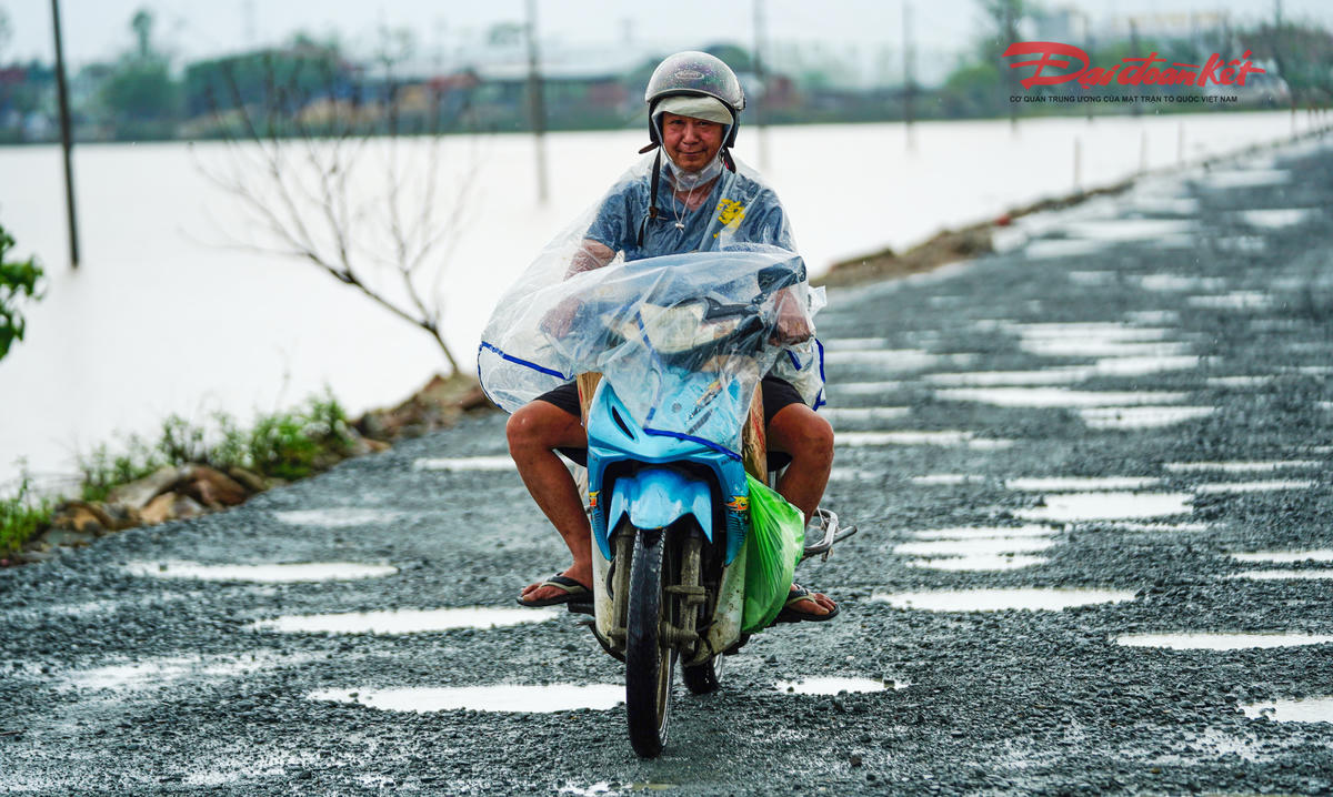 Trao đổi với Báo Đại đoàn kết, ông Hà Đức Nhanh, Phó giám đốc Công ty CP Xây dựng và Thương mại Ngọc Minh cho biết, từ đầu tháng 8/2025, đơn vị đã huy động nhân lực, máy móc, vật liệu, dựng lán trại để triển khai công việc. nhiều vị trí nền cũ bằng bê tông xi măng đã được đục bỏ và dặm vá bằng lớp base, những điểm hư hỏng nặng đang được khắc phục trước khi thảm hai lớp bê tông nhựa hoàn thiện. Dự kiến sau khi hoàn thành, mặt đường sẽ cao hơn nền cũ từ 40 – 60 cm, góp phần tránh ngập úng cục bộ khi mưa lớn. Ảnh: Cẩm Kỳ&nbsp;