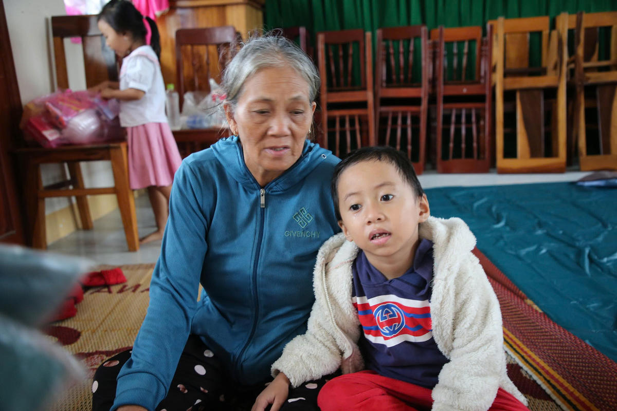 Bà Đặng Thị Thanh cùng cháu tại khu sơ tán tránh bão số 13. Ảnh: Tấn Thành.