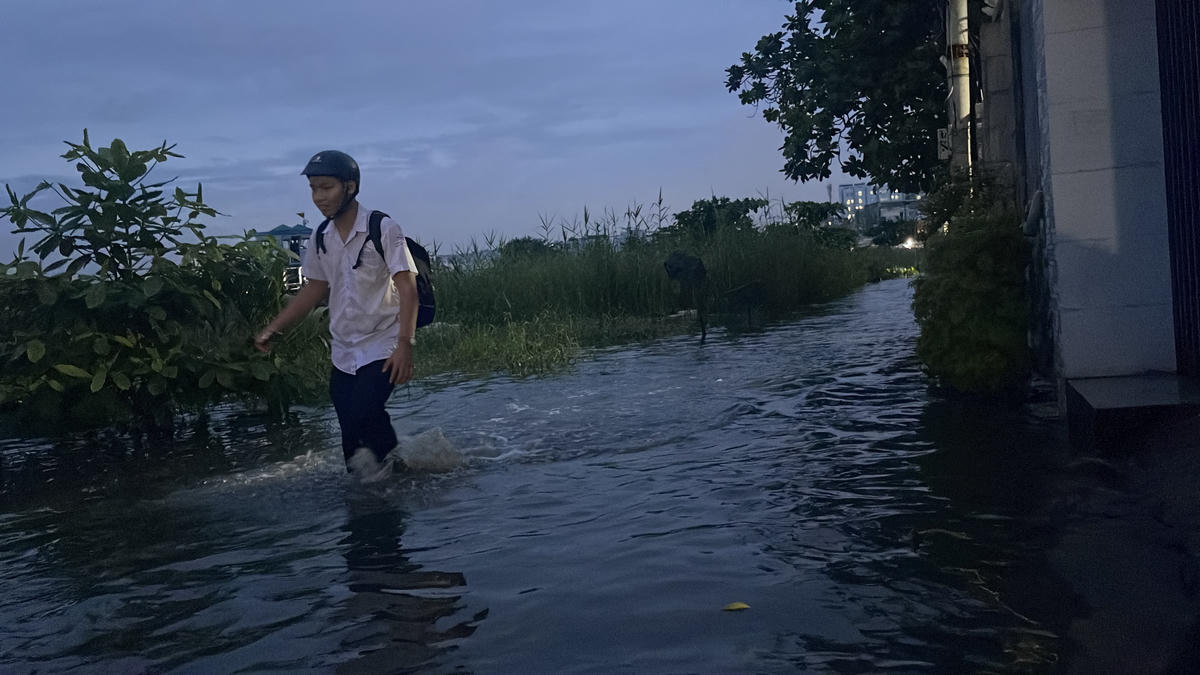 Học sinh lội nước về nhà vì xe bị chết máy. Ảnh: Đ.Xá.