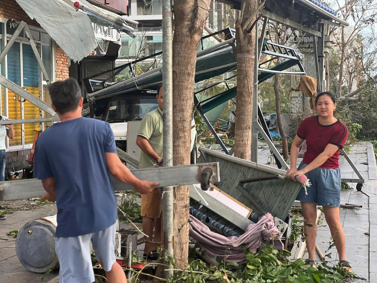 Chị&nbsp;Hà Thị Cẩm Vân cùng chồng dọn dẹp đống đổ nát sau bão số 13. Ảnh Chí Đại.