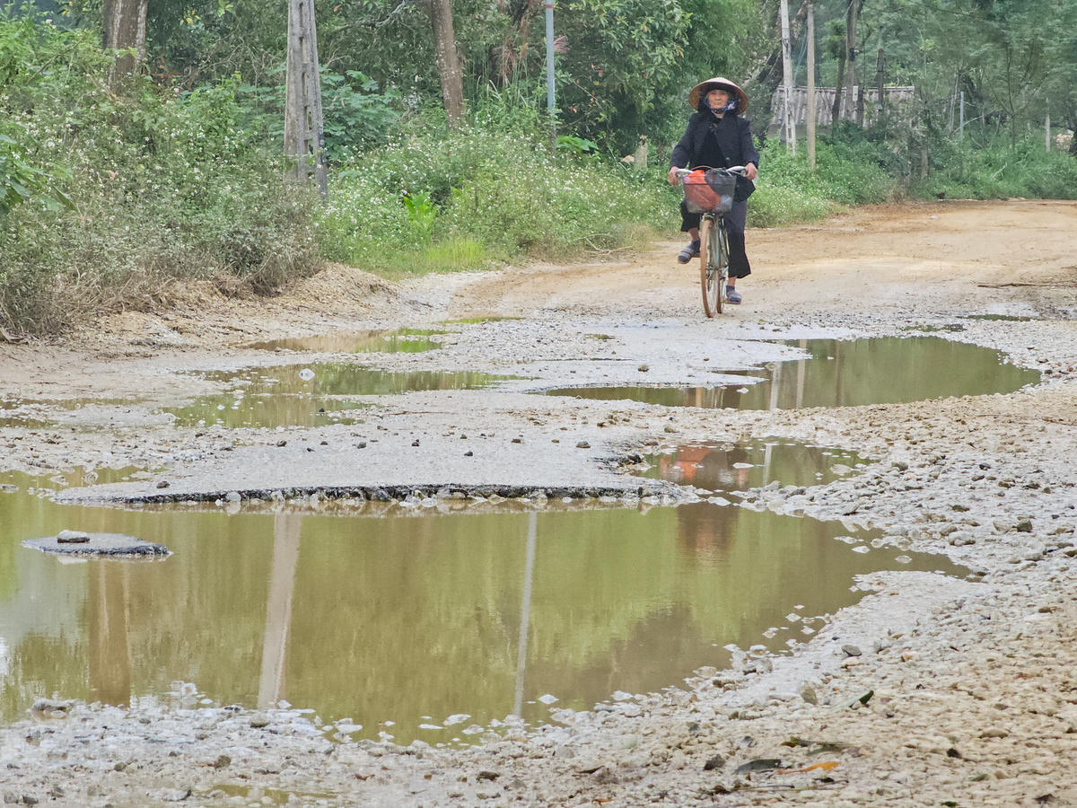 Người dân vất vả khi đi qua con đường xuống cấp. Ảnh: Đình Minh