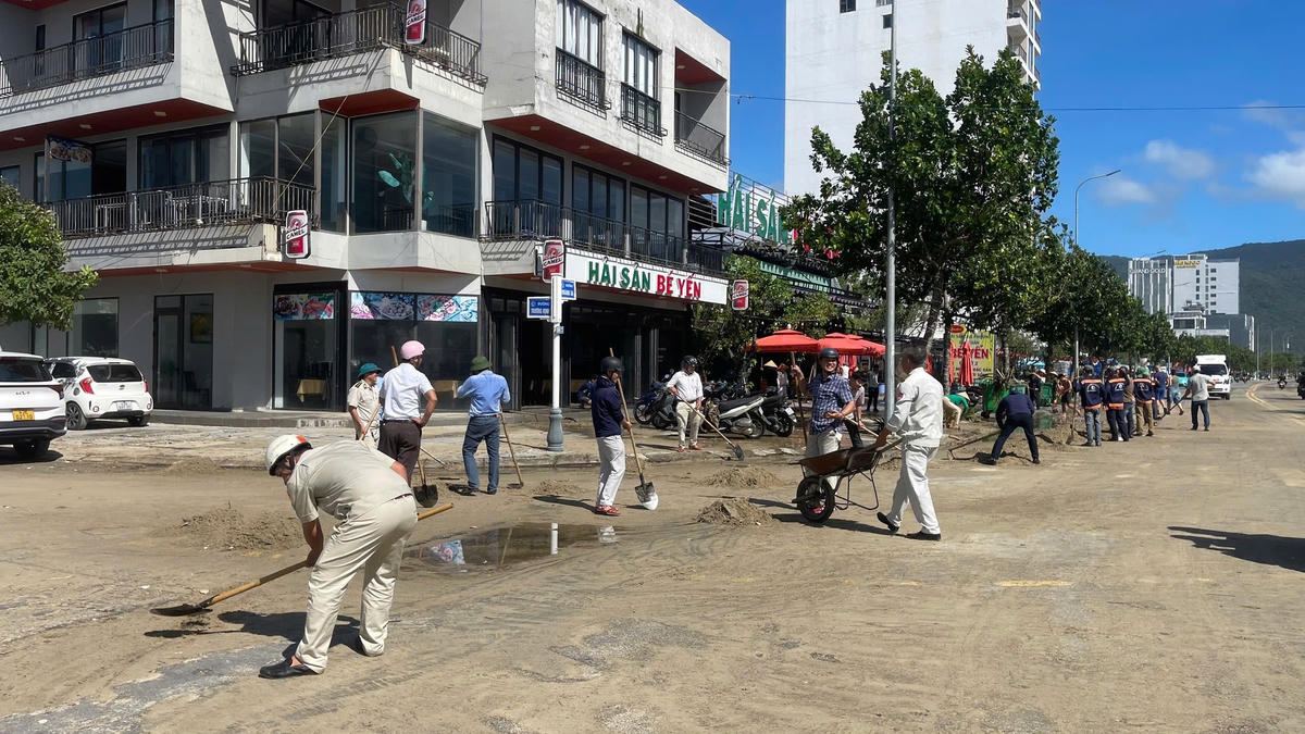 Lực lượng phường Sơn Trà tham gia dọn cát. Ảnh: Nguyễn Tú.