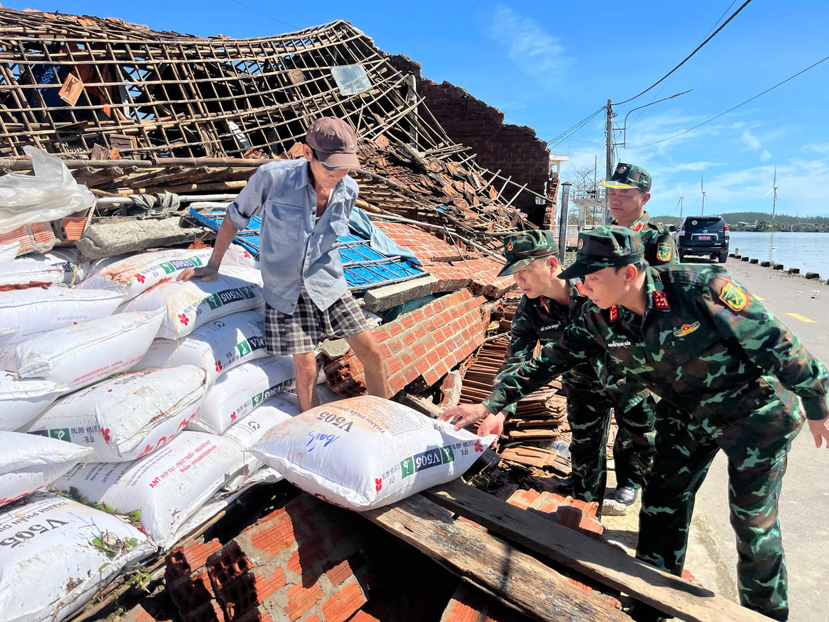 Lãnh đạo Quân khu 5 thăm, giúp đỡ người dân xã Tuy Phước Đông, tỉnh Gia Lai bị sập đổ nhà sau bão số 13. Ảnh: CV.