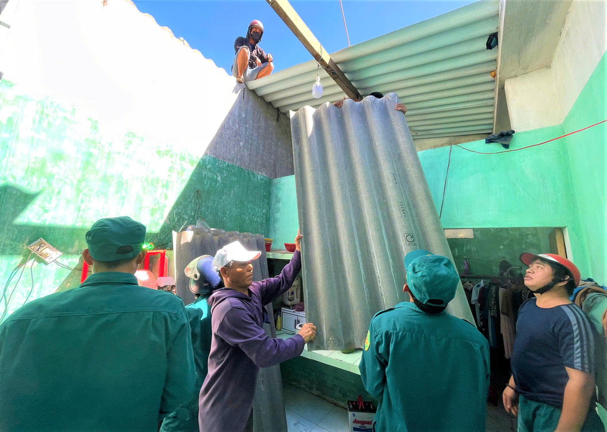 Lực lượng chức năng giúp dân lợp lại mái nhà. Anh: Chí Đại