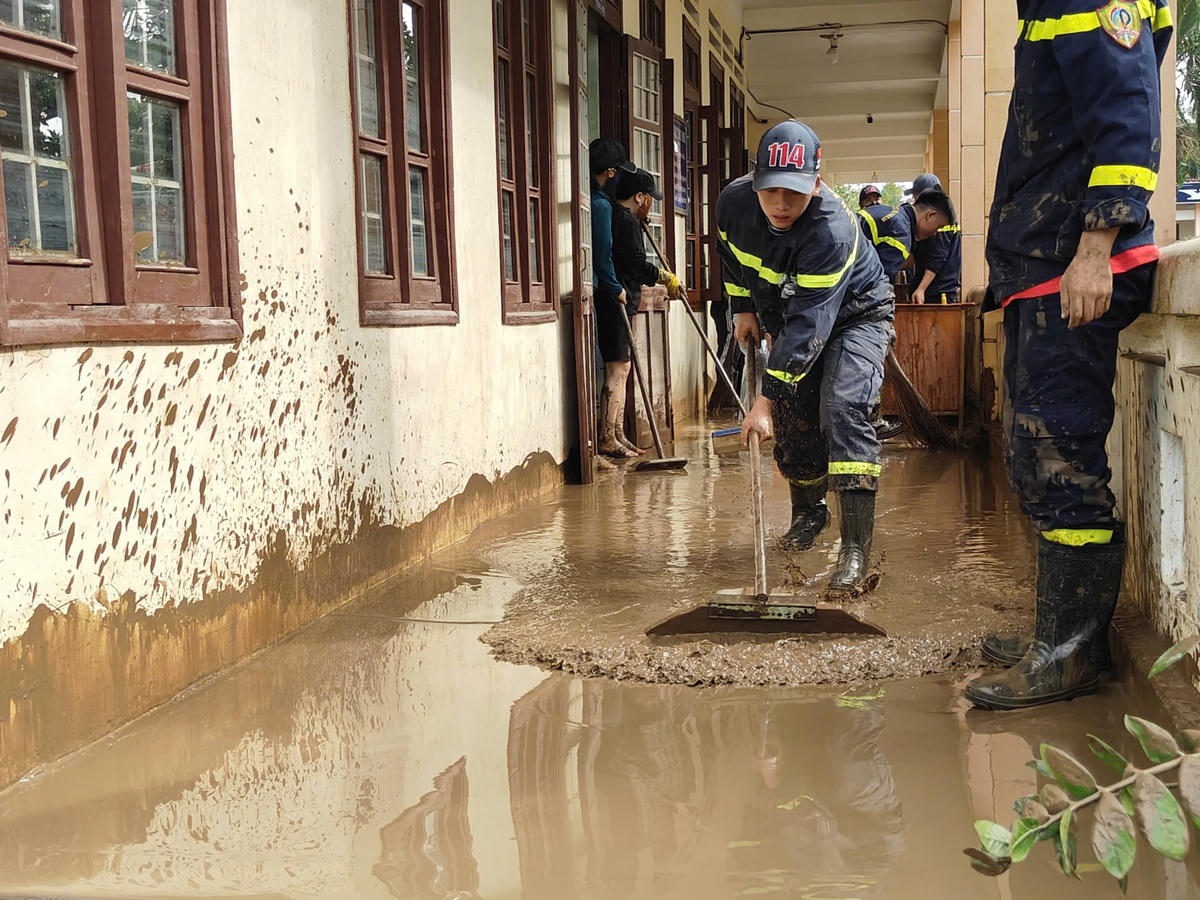 Lực lượng Đoàn Thanh niên Công an khẩn trương tẩy rửa bùn đất, vệ sinh trường học. Ảnh: SĐ.