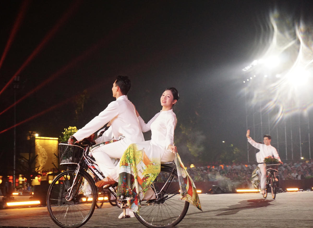 Hình ảnh những cô gái trong tà áo dài thướt tha đạp xe giữa không gian lễ hội gợi nhớ vẻ đẹp thanh lịch, nền nã - biểu tượng quen thuộc của Hà Nội xưa và nay.