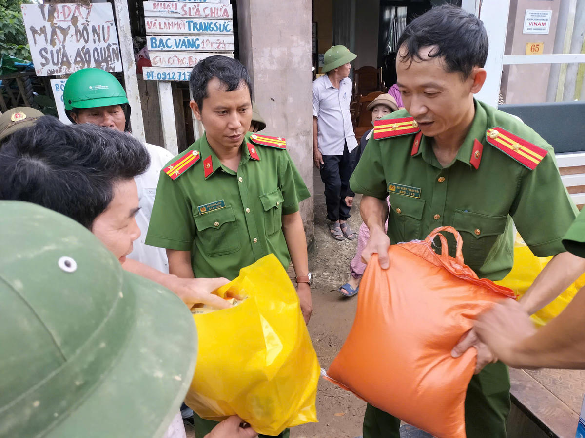 Các chiến sĩ công an đến tận nhà trao quà cho người dân vùng lũ. Ảnh Phước Thành