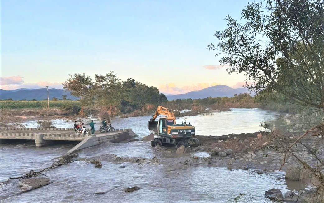 Lực lượng chức năng đang khắc phục điểm sạt lở đường bê tông dẫn vào làng Hrách, xã Sró. Ảnh: CV.