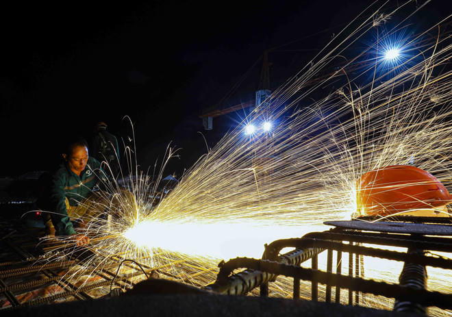 Trên công trường xây dựng Trường Liên cấp Tiểu học – Trung học cơ sở xã Si Pa Phìn (tỉnh Điện Biên) - trường khởi công đầu tiên trong số 100 trường, hơn 400 công nhân chia ca làm việc xuyên ngày đêm để kịp tiến độ. (Ảnh: Xuân Tư/TTXVN).