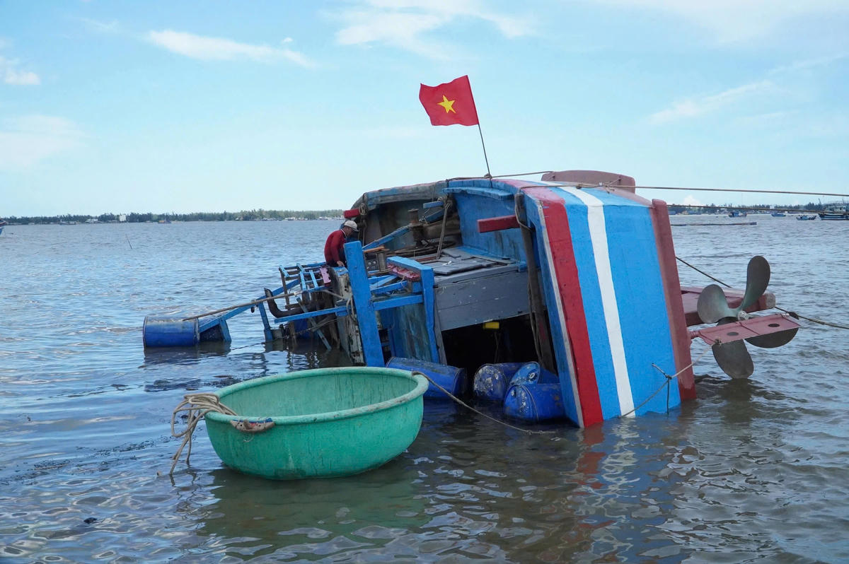 Một tàu cá của ngư dân xã Đề Gi, tỉnh Gia Lai bị sóng biển đánh lật nghiên sau cơn bão số 13. Ảnh: Chí Đại.