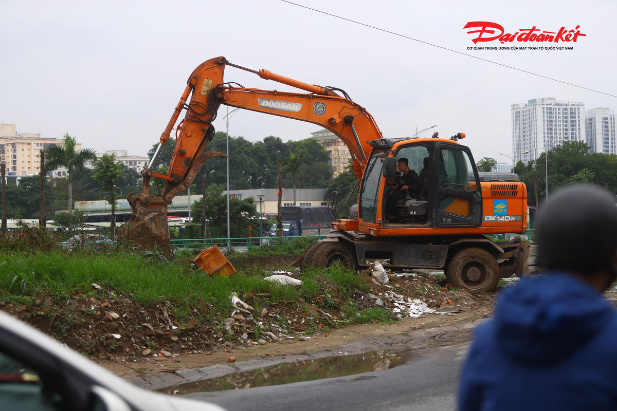 Phía sát bờ sông, công nhân lái máy tiến hành san gạt để lấy mặt bằng thi công.