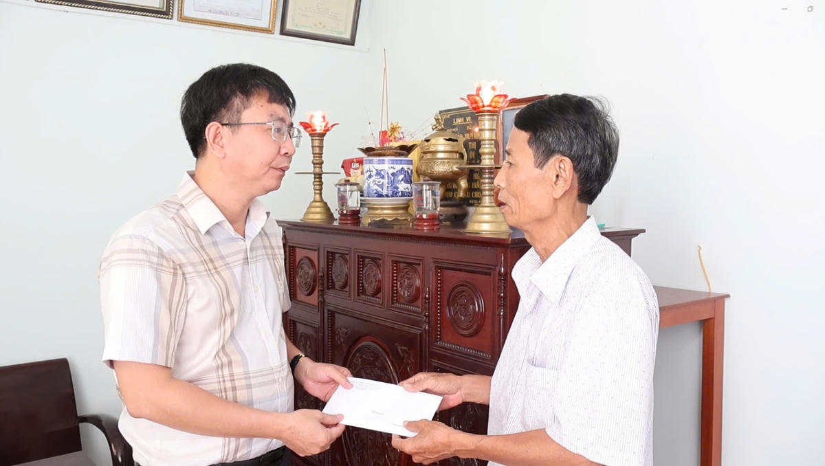 Ông Hoàng Thanh Hòa, Bí thư Đảng ủy phường Hải Vân (bên trái), động viên hỗ trợ gia đình ông Lê Đình Xê. Ảnh: Nguyễn Tú