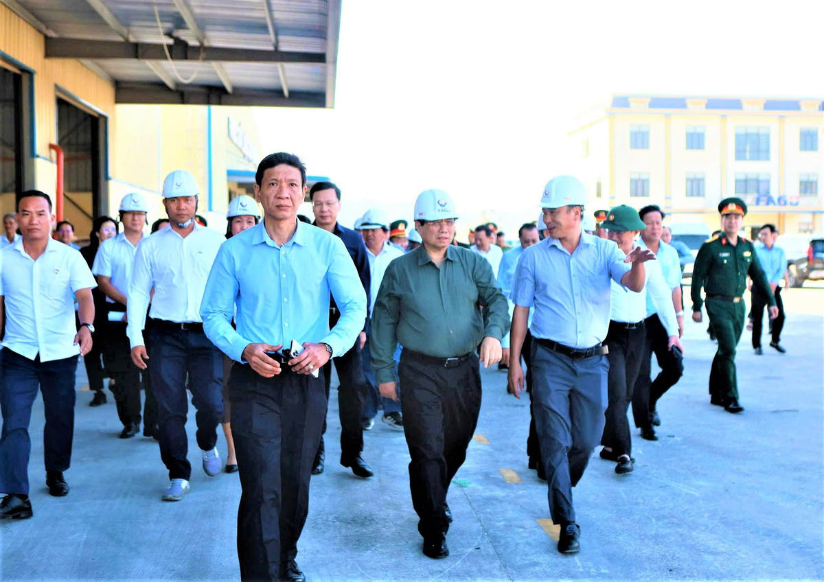Thủ tướng Phạm Minh Chính (ở giữa) đến thăm và kiểm tra tình hình thiệt hại do bão số 13 tại Công ty Thức ăn Chăn nuôi Fago. Ảnh: Chí Đại.