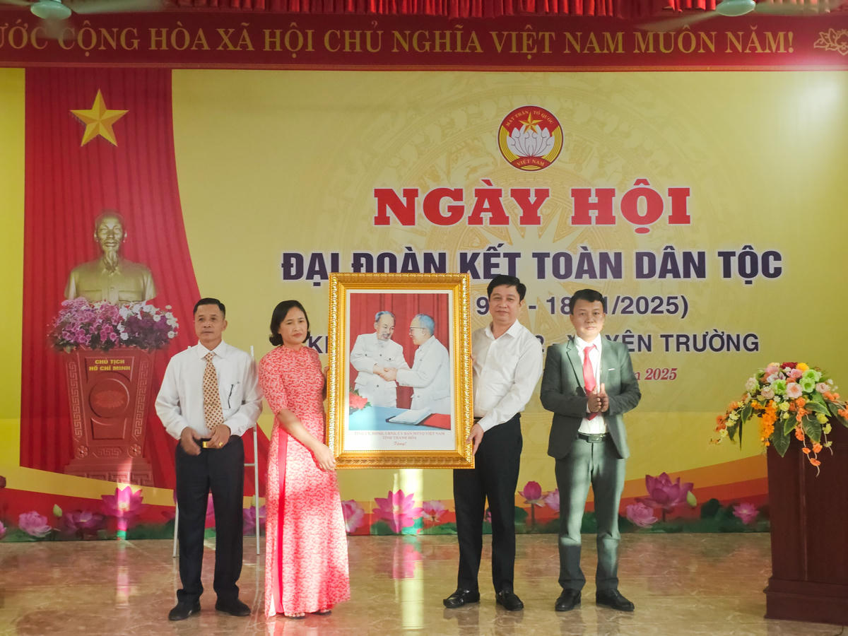 Ông Trịnh Xuân Thúy - Chánh Thanh tra tỉnh trao tặng thôn 2 bức ảnh Bác Hồ bắt tay Bác Tôn. Ảnh: Đình Minh