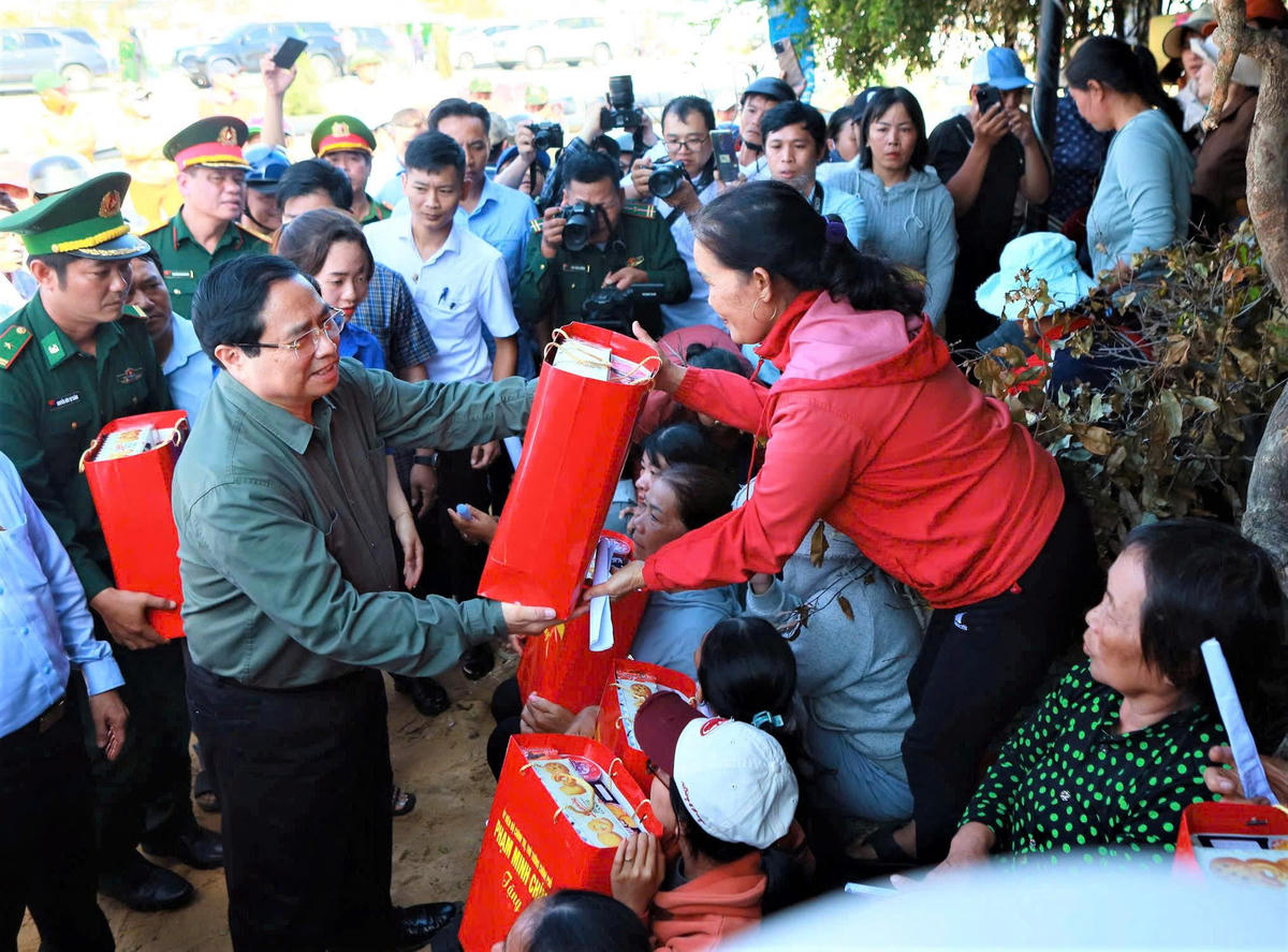Thủ tướng Phạm Minh Chính tặng quà cho người dân xã Đề Gi. Ảnh: Đình Sang.
