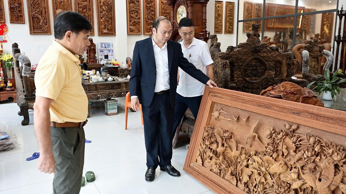 Ông Nguyễn Hữu Chi - Chủ tịch UBND xã tham quan một xưởng đồ gỗ mỹ nghệ trên địa bàn.