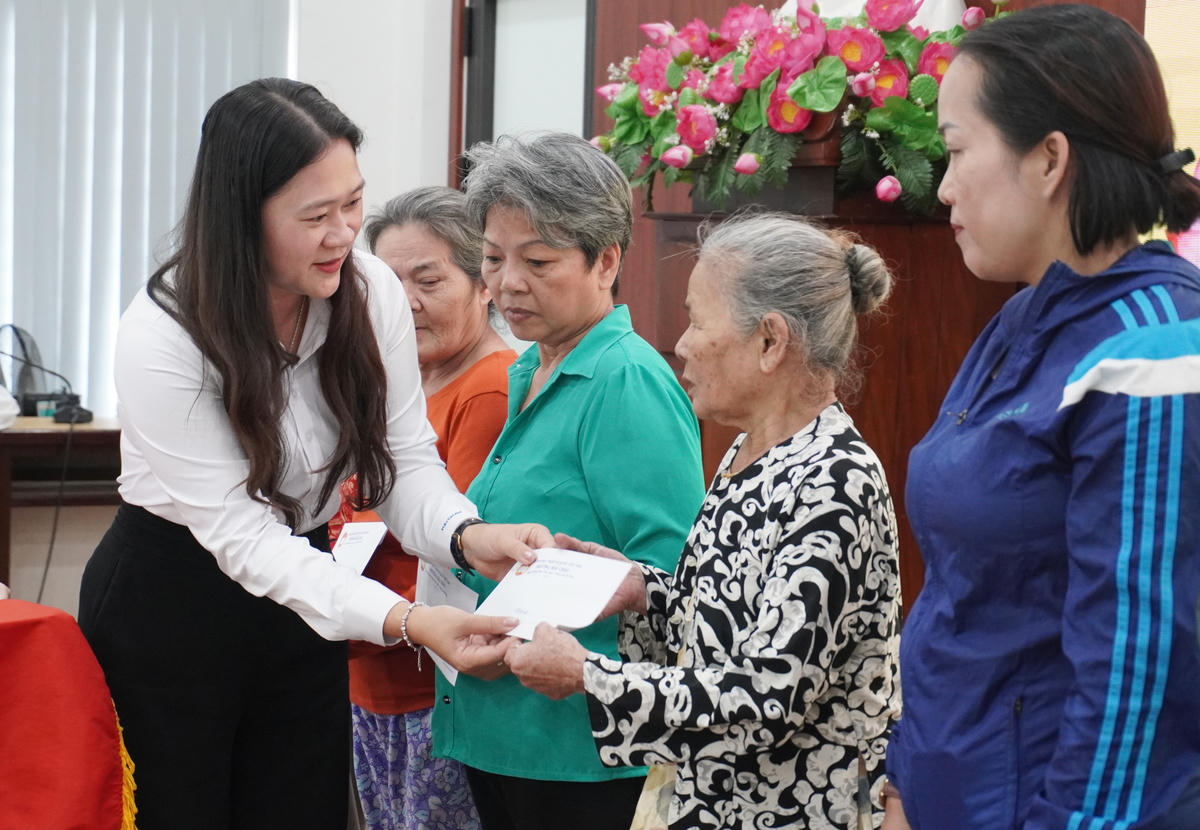 Bà Cao Thị Huyền Trân, Bí thư Đảng ủy, Chủ tịch HĐND lâm thời phường Hải Châu, tặng quà cho 10 hộ dân. Ảnh: Nguyễn Tú.