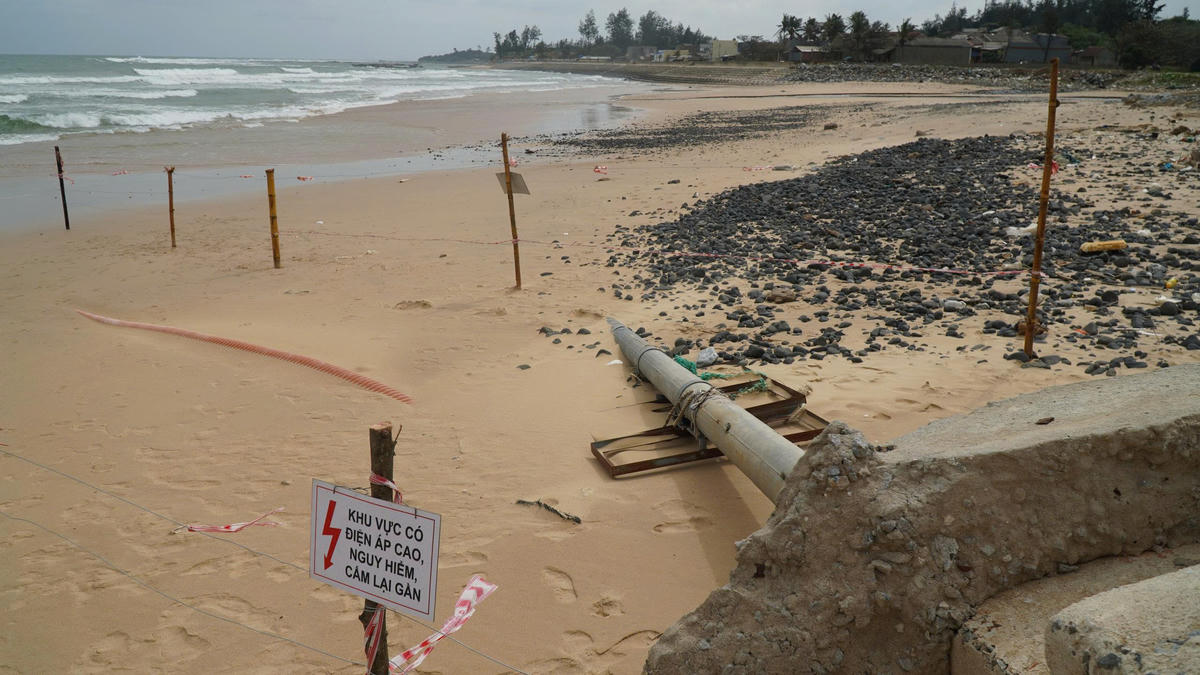 Đường cáp điện nổi trên mặt bờ biển sau bão số 13, cạnh trụ biển báo bị đổ. Ảnh: CV.