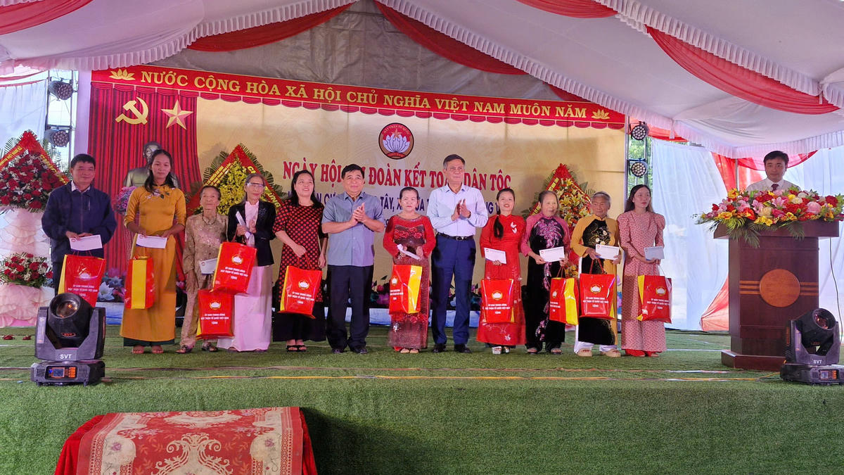 Phó Thủ tướng Nguyễn Chí Dũng và Phó Bí thư Đảng ủy Mặt trận Tổ quốc, các đoàn thể Trung ương Trần Thắng trao quà cho người dân ở khu dân cư Liêm Công Tây. Ảnh: ĐV.