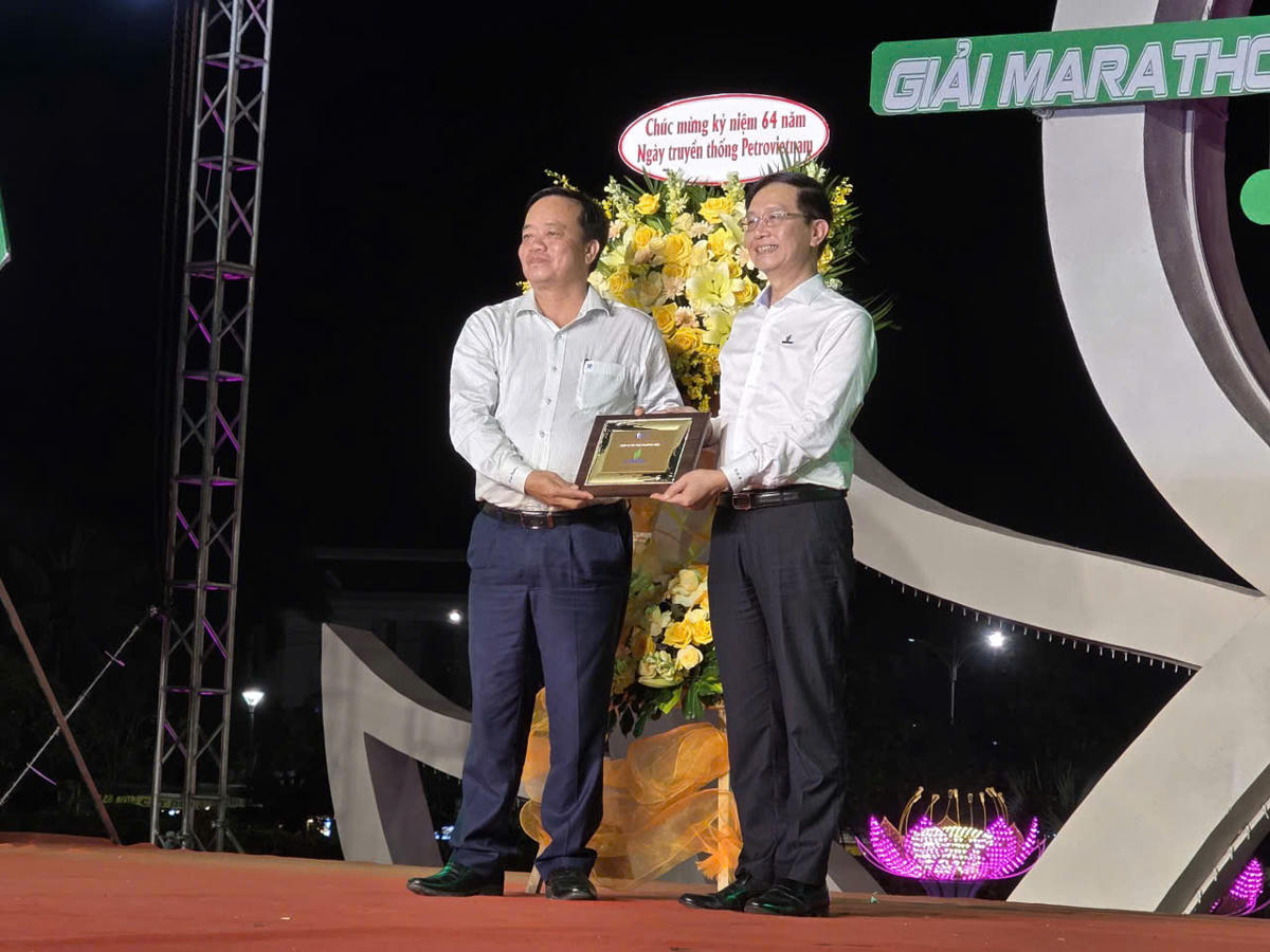 Phó bí thư thường trực Tỉnh ủy, Chủ tịch Ủy ban MTTQ Việt Nam tỉnh Cà Mau Huỳnh Quốc Việt tặng hoa và biểu trưng cảm ơn nhà tài trợ thương hiệu từ Ban tổ chức giải. Ảnh: Nguyên Du