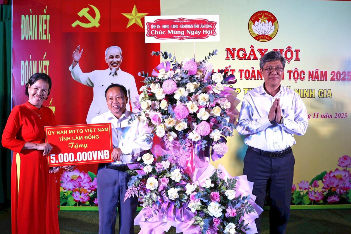 Ông Nguyễn Minh, Phó Chủ tịch UBND tỉnh Lâm Đồng tặng hoa và quà cho cán bộ và Nhân dân thôn Hiệp Thuận tại ngày hội. (ảnh T.V)