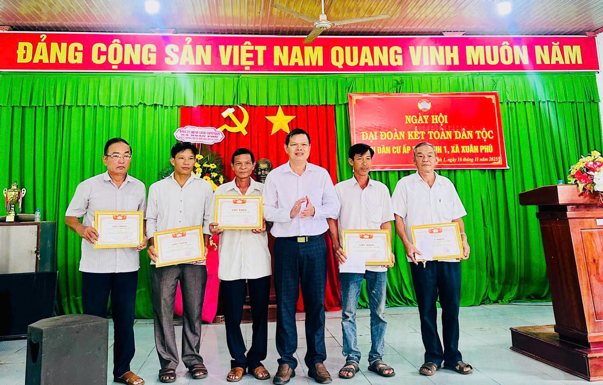 Ông Trần Văn Hoàng, UV BTV Đảng ủy, Chủ nhiệm UBKT Đảng ủy xã Xuân Phú trao Giấy khen cho các cá nhân tiêu biểu trong phong trào thi đua yêu nước. Ảnh: Phi Nhật.