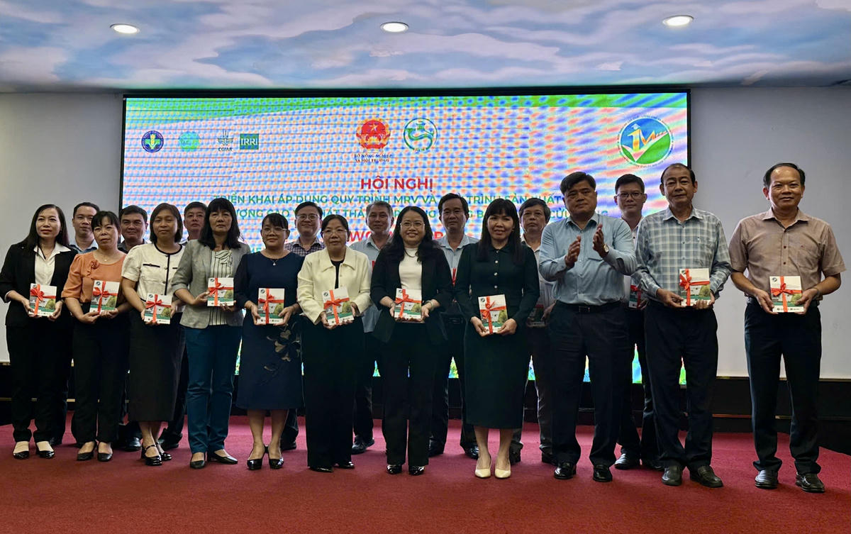 Thứ trưởng Bộ Nông nghiệp và Môi trường Trần Thanh Nam trao sổ tay Quy trình sản xuất lúa chất lượng cao, phát thải thấp. (ảnh: P.H)