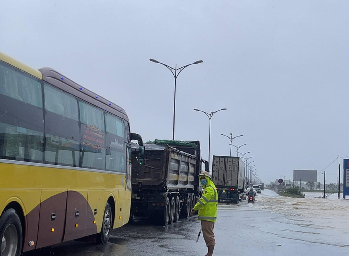 Lực lượng chức năng tham gia điều tiết giao thông tại những vị trí ngập sâu. Ảnh: H.N