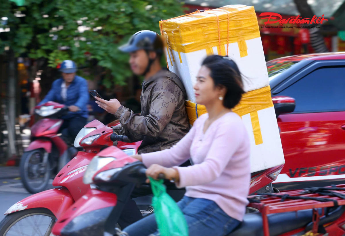 Hình ảnh tài xế lái xe máy dùng điện thoại gây mất an toàn giao thông. Ảnh: Lê Khánh.