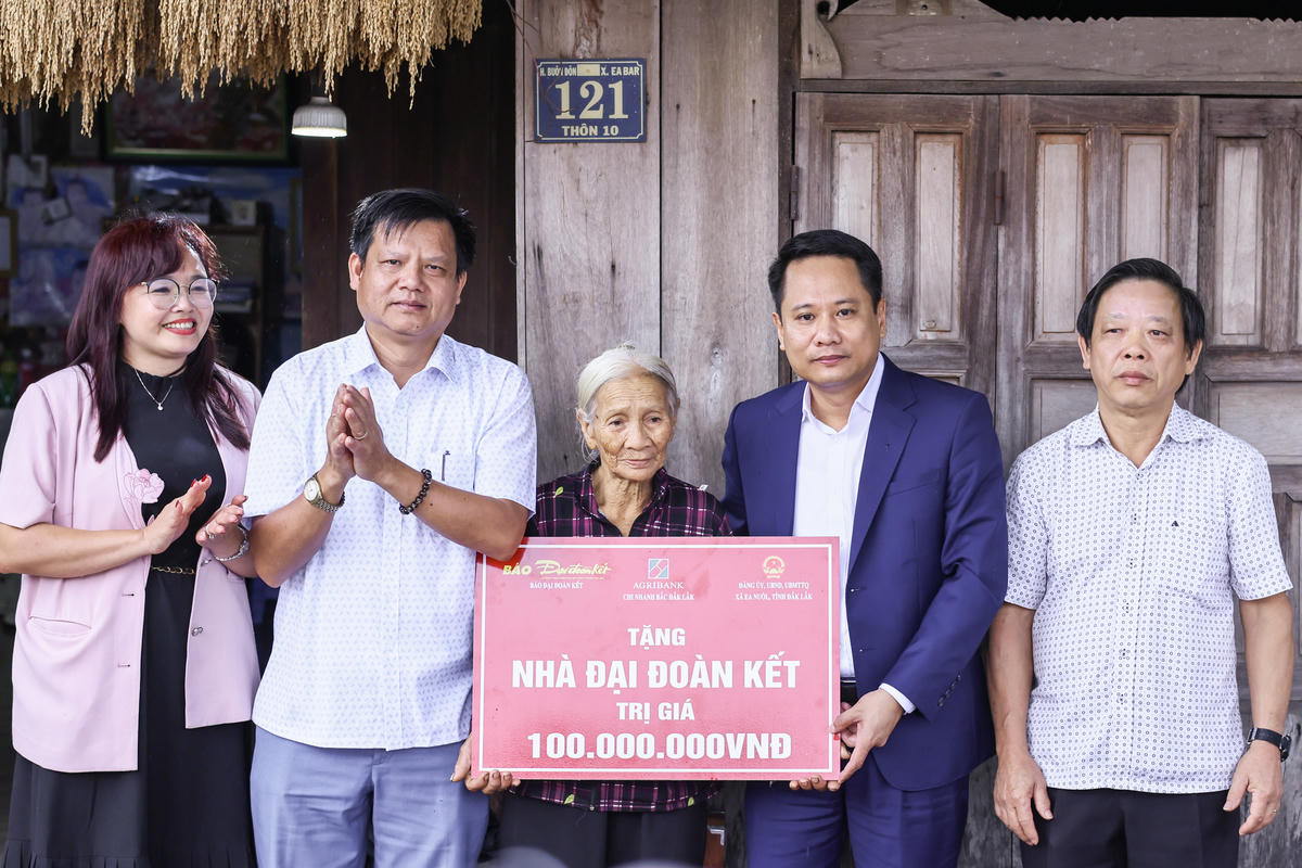 Nhà báo Trương Thành Trung, Tổng Biên tập Báo Đại đoàn kết cùng đại diện lãnh đạo Agribank chi nhánh Bắc Đắk Lắk trao tặng nhà Đại đoàn kết trị giá 100 triệu đồng cho gia đình bà Lê Thị Hà. Ảnh: Quang Vinh.