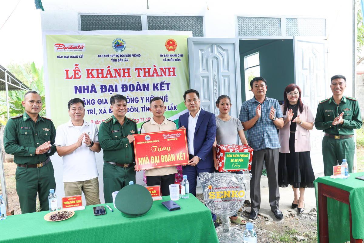 Nhà báo Trương Thành Trung, Tổng Biên tập Báo Đại đoàn kết  và Đại tá Rơ Lan Ngân, Phó Chính ủy Bộ Chỉ huy Bộ đội Biên phòng tỉnh Đắk Lắk bàn giao nhà cho con ông Y Hớn Niê. Ảnh: Quang Vinh.