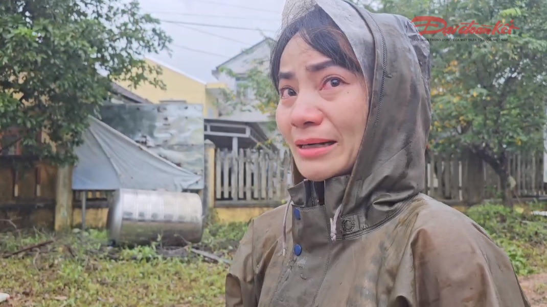 Bà Nhân nghẹn ngào khi nhìn hàng hoá của mình bị lũ nhấn chìm. Ảnh: N.Q.