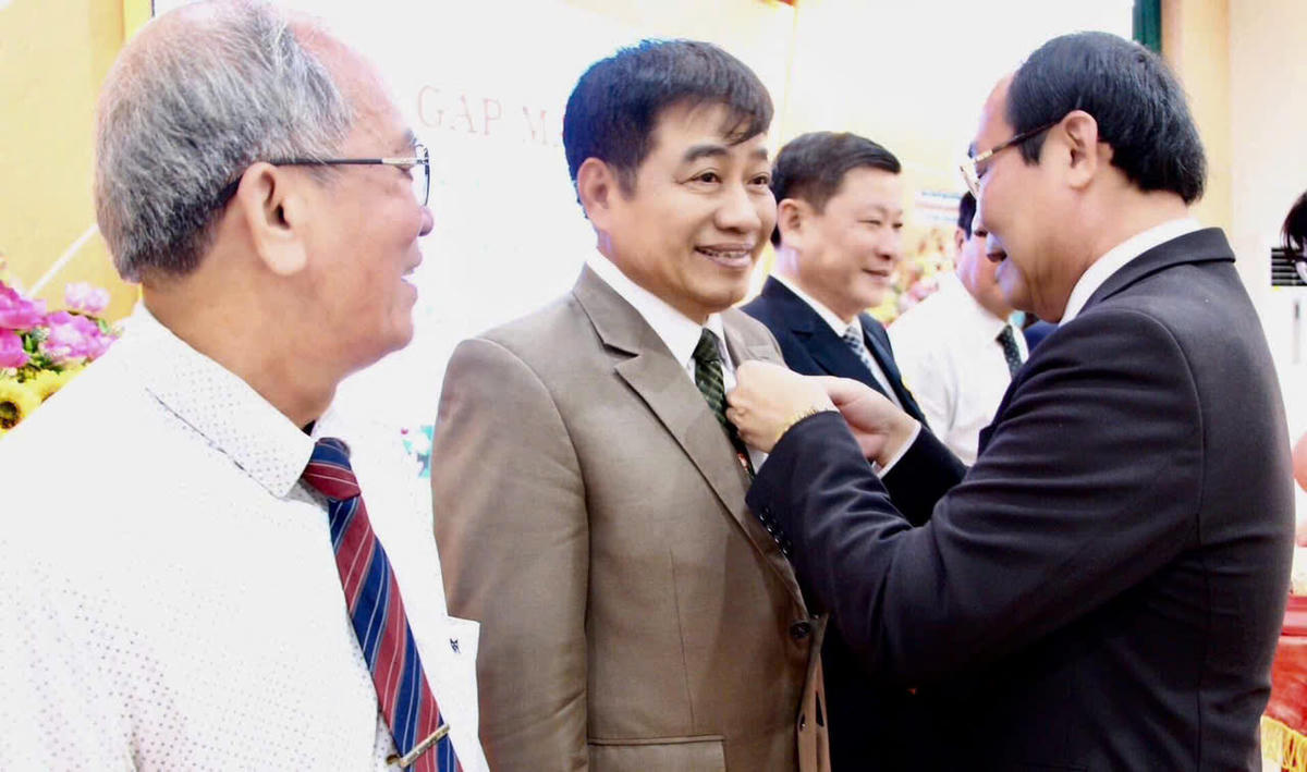 Ông Võ Xuân Ca, khi còn là UVTW MTTQ Việt Nam, UVBTV Tỉnh uỷ Quảng Nam thừa uỷ nhiệm của UBTƯ MTTQ Việt Nam trao Kỷ niệm chương Vì sự nghiệp Đại đoàn kết dân tộc cho tác giả. Ảnh: NVL.