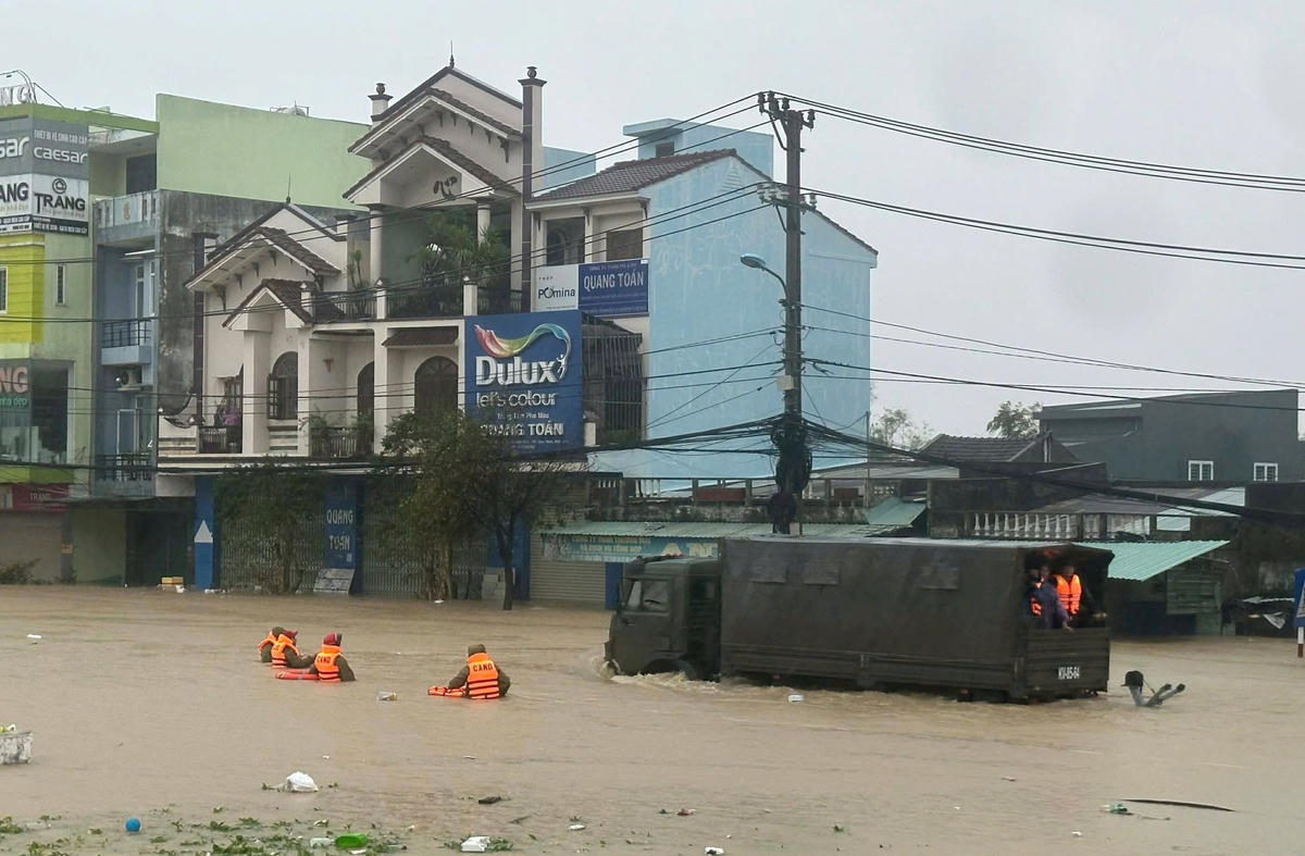 Cán bộ, chiến sĩ lội nước đưa người dân ở vùng ngập sâu đến địa khác an toàn. Ảnh: CV.