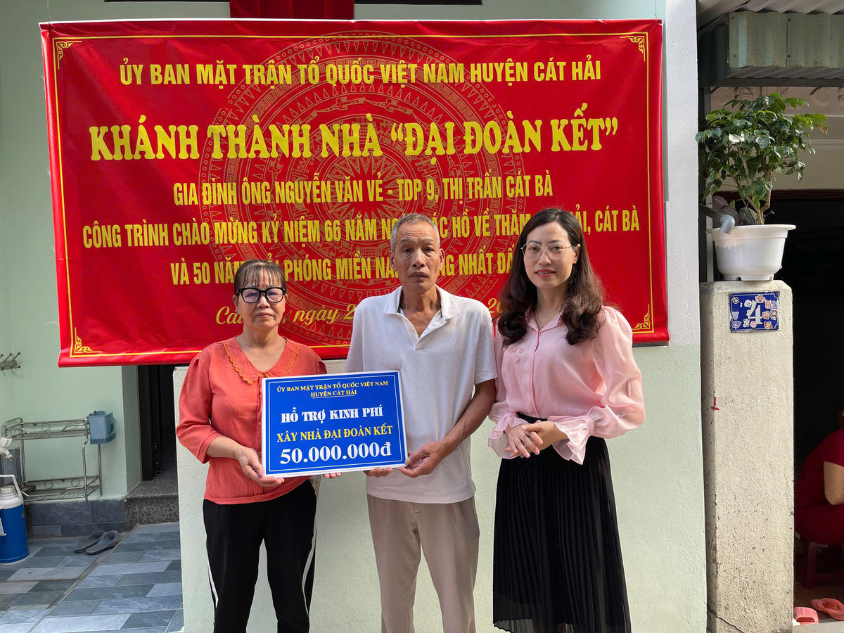 Chị Liên chia vui với gia đình ông Nguyễn Văn Vẻ trong ngày khánh thành nhà Đại đoàn kết. Ảnh: NVCC. 