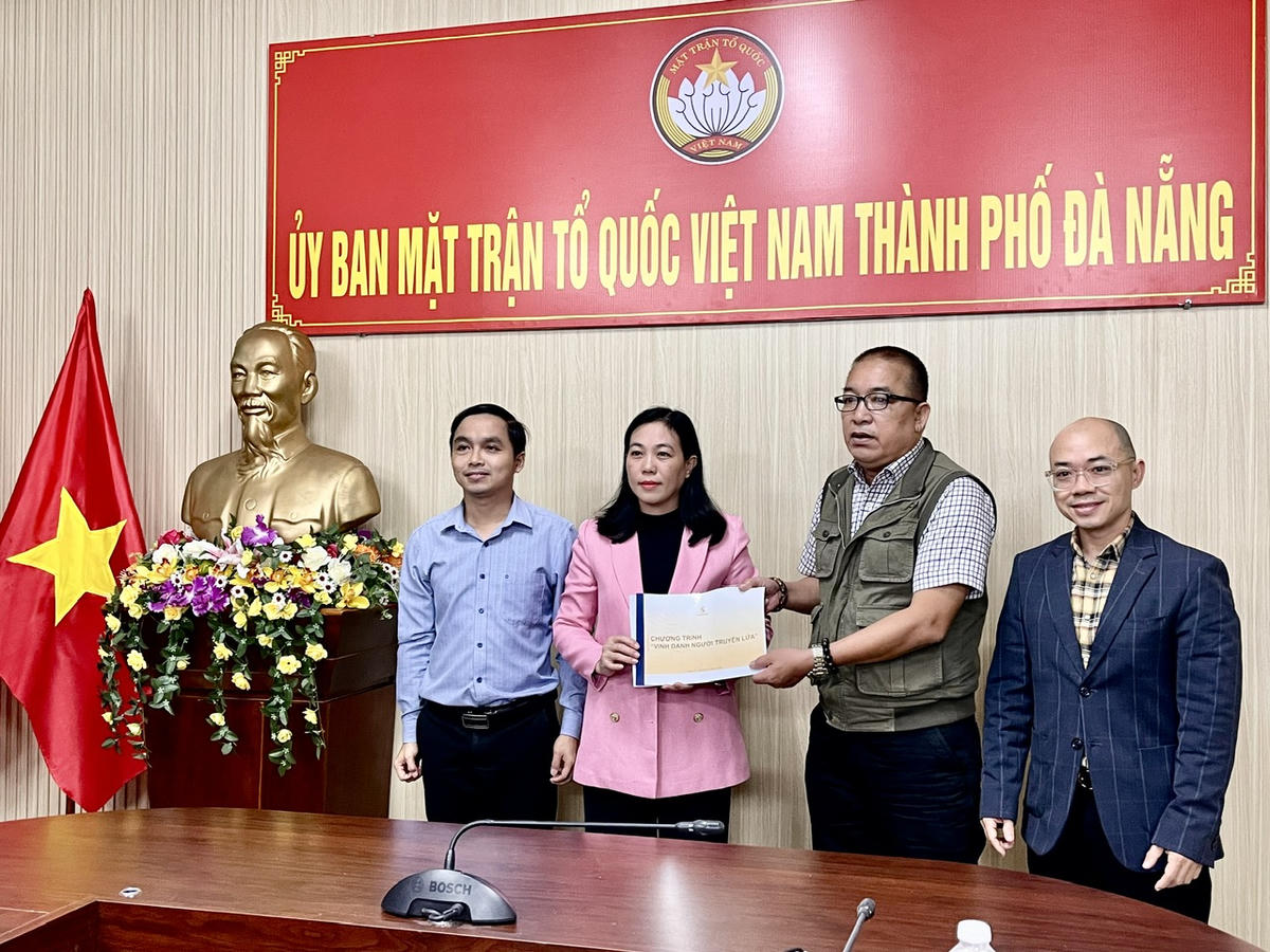 Nhà báo Đinh Tấn Thành trao tài liệu về Giải thưởng “Vinh danh Người truyền lửa” cho lãnh đạo Ủy ban MTTQ Việt Nam TP Đà Nẵng. Ảnh: Huy Trường.