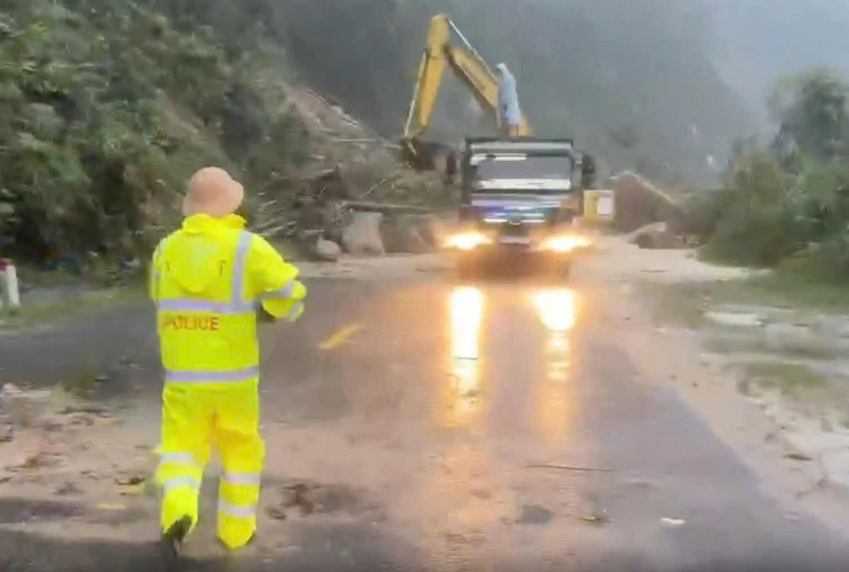 Lực lượng chức năng đang nỗ lực dọn dẹp đoạn đường bị sạt lở.&nbsp; Ảnh: CA.