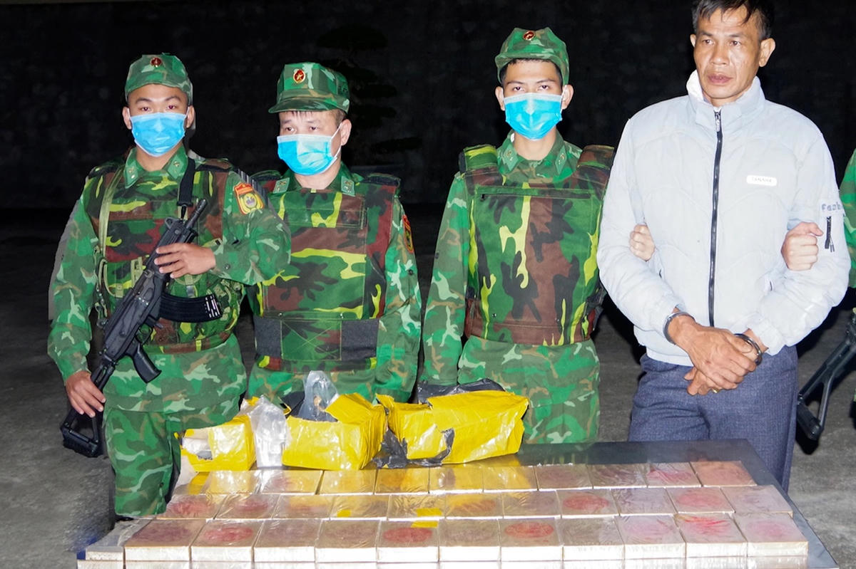 Lê Tuấn Hiên cùng 32 bánh heroin bị thu giữ. Ảnh: Hải Chuyền