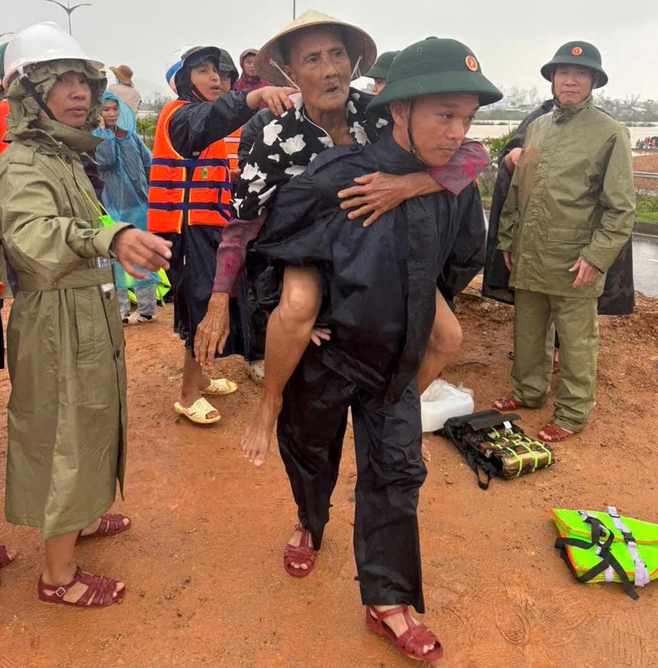 Chiến sĩ của Bộ CHQS tỉnh Gia Lai cõng người già ở xã Tuy Phước vùng ngập lụt đến nơi an toàn. Ảnh: CV.