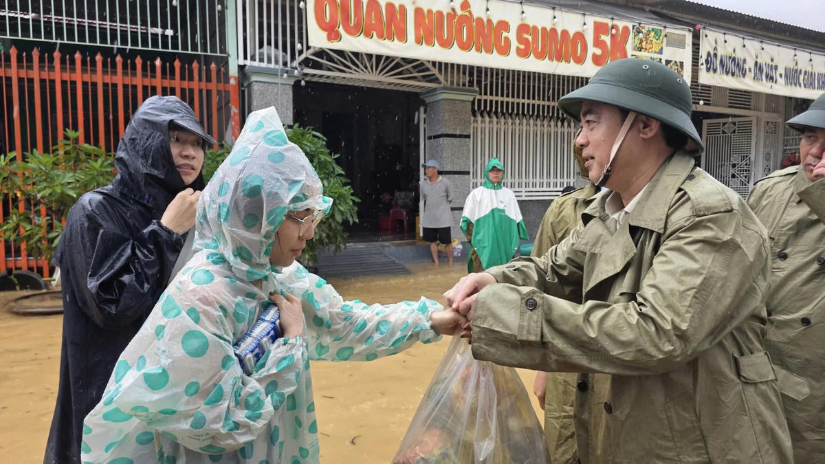 Ông Nghiêm Xuân Thành, Bí thư Tỉnh ủy Khánh Hòa trao nhu yếu phẩm hỗ trợ cho người dân vùng lũ. (ảnh M.H  )