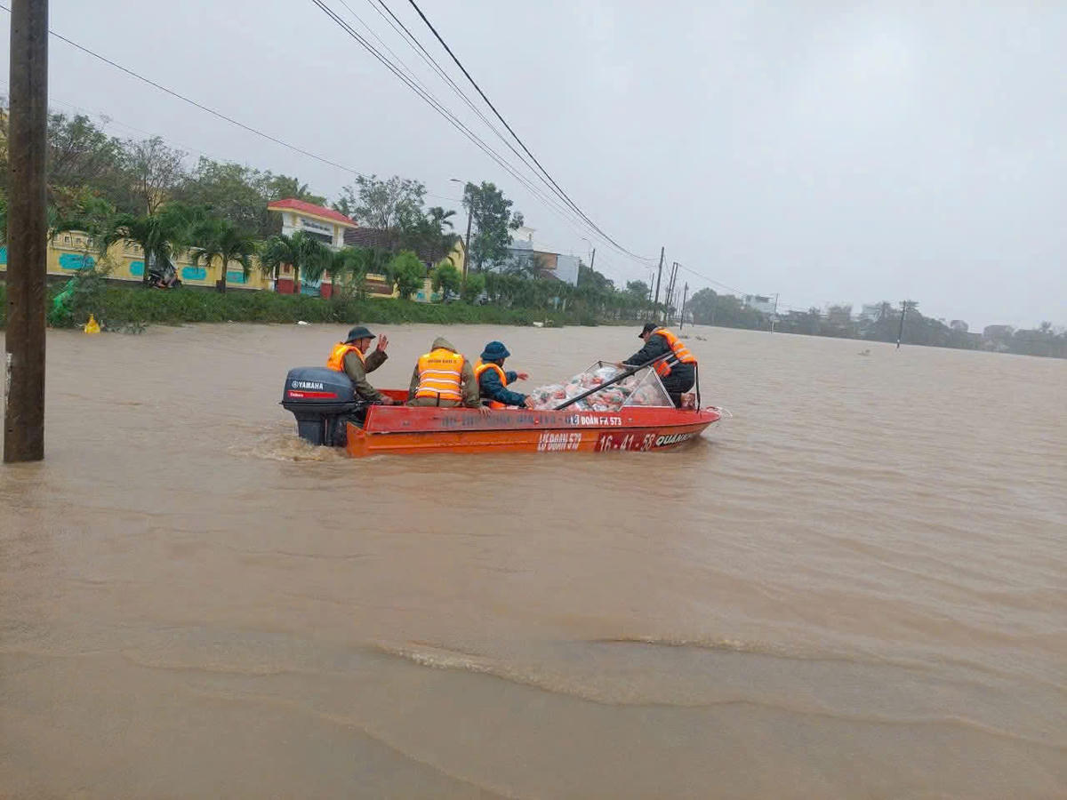 Cán bộ, chiến sĩ, Lữ đoàn 573 vượt dòng nước xiết để vận chuyển lương thực, thực phẩm tiếp tế cho bà con nhân dân. (ảnh Đ.S)

