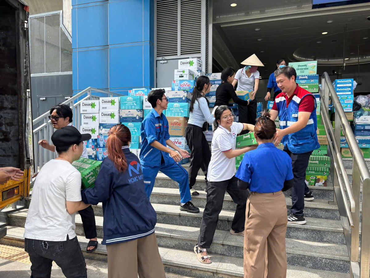 Nhân viên metro phối hợp với lực lượng chức năng vận chuyển hàng hoá của người dân. Ảnh: M.T.