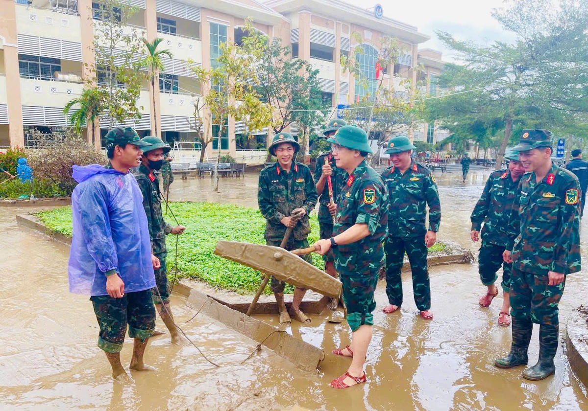 Lực lượng Quân khu 5 dọn dẹp cùng người dân tại xã Phú Hòa 2. (ảnh Đ.S)