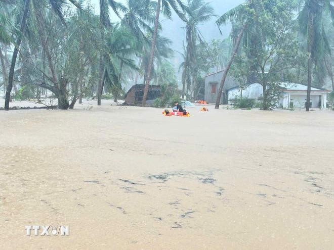 Lực lượng chức năng xã Xuân Cảnh, Đắk Lắk cứu nạn người dân ở khu vực ngập sâu. (Ảnh: TTXVN phát).