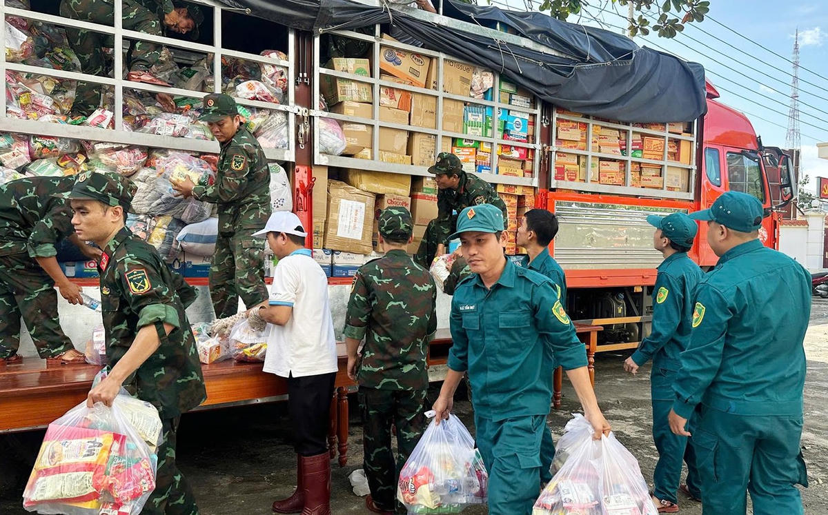 Các lực lượng tiếp nhận nhu yếu phẩm để phân bổ, vận chuyển đến các xã, phường bị lũ lụt. (ảnh L.A)